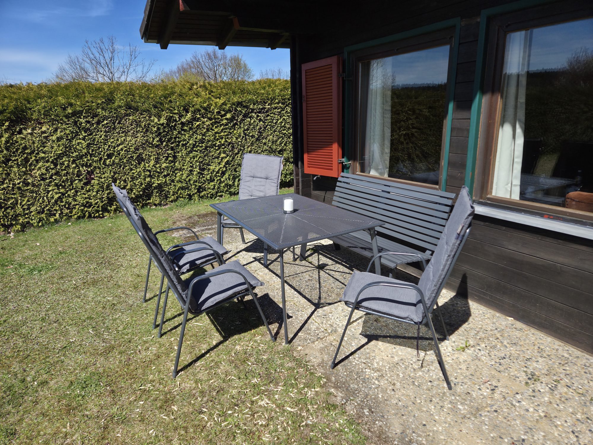Eingezäunter Garten mit Sitzplatz und Hecke an der Schmugglerhütte
